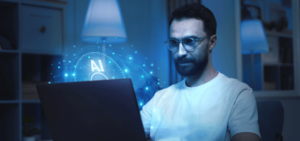 Hombre con gafas sentado frente a la pantalla de un ordenador portátil leyendo sobre Inteligencia Artificial